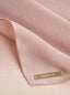 Suri Cotton TudungPeople signature hijab in soft fabric, displayed on a stand with intricate detailing.