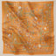 TudungPeople Atelier warm orange print square scarf displayed flat, showcasing vibrant color and detailed design.